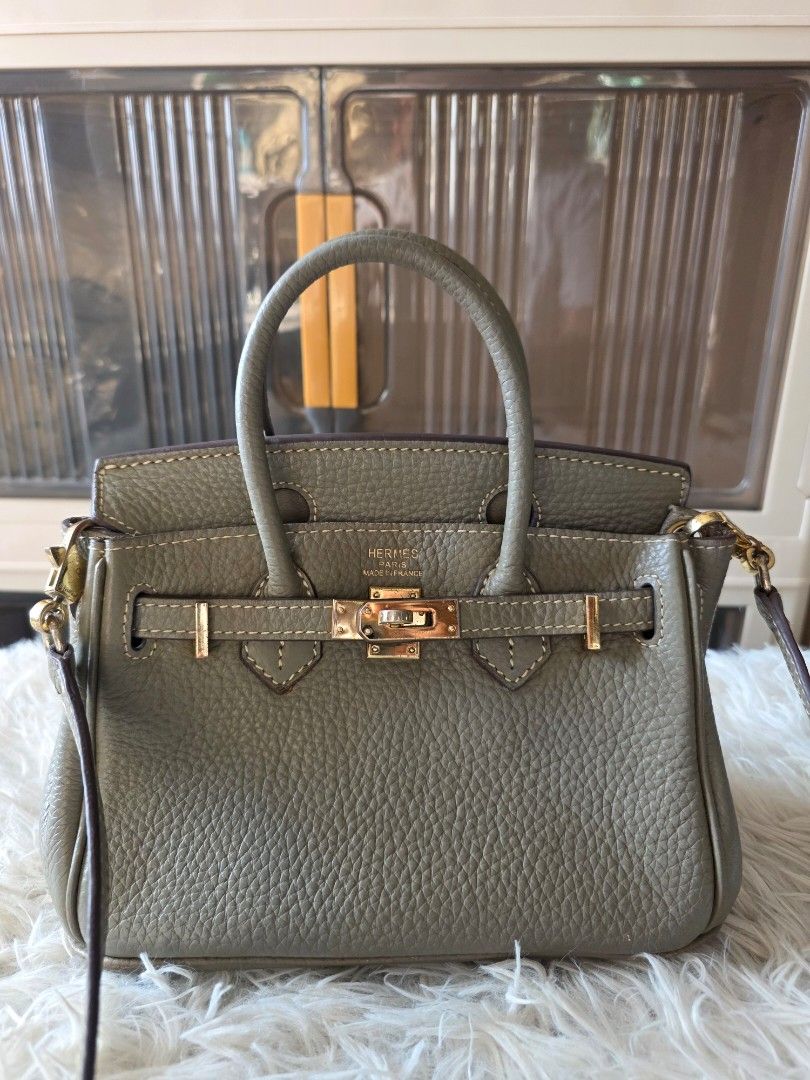 Hermès Birkin Handbag Grey (Category: Cross-body Bags) located in Lemery. Submitted by venus23 (Listing ID 1470139326, Image 2). Description: - Style: Hermès Birkin Handbag - Material: Premium grey pebbled leather -Zipper: Riri underzip - Hardware: Elegant gold-tone with classic front flap and turn-lock closure - Size: Approx. 20cm across the bottom base - Features: Double top handles, detachable long crossbody strap, and 4 protective metal feet 