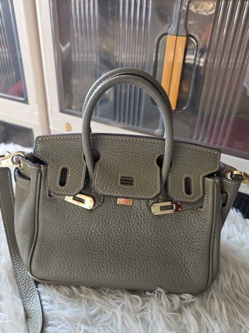 Hermès Birkin Handbag Grey (Category: Cross-body Bags) located in Lemery. Submitted by venus23 (Listing ID 1470139326, Image 1). Description: - Style: Hermès Birkin Handbag - Material: Premium grey pebbled leather -Zipper: Riri underzip - Hardware: Elegant gold-tone with classic front flap and turn-lock closure - Size: Approx. 20cm across the bottom base - Features: Double top handles, detachable long crossbody strap, and 4 protective metal feet 