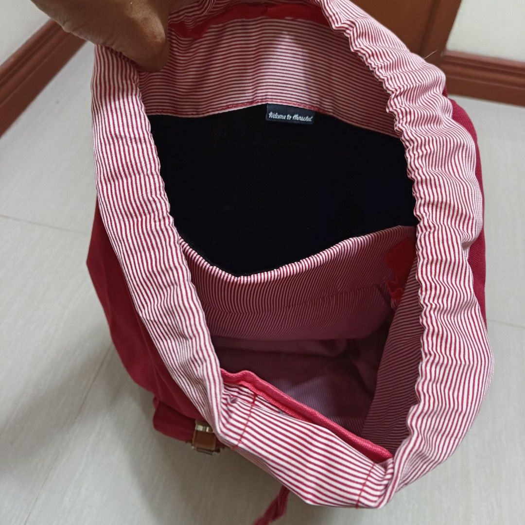 Herschel Backpack Red with Laptop Compartment (Category: Backpacks) located in Nasugbu. Submitted by staffpicks1515 (Listing ID 1470093162, Image 3). Description: - Brand: Herschel - Color: Vibrant red with brown leather-look details - Interior: Signature red and white striped lining with a dedicated padded laptop sleeve - Exterior: Front zippered pocket with classic woven brand patch and magnetic snap closures - Comfort: Adjustable shoulder stra