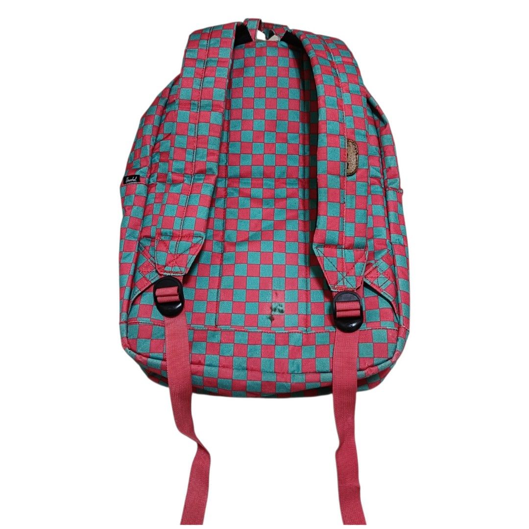 Herschel Supply Co. Checkered Pink and Turquoise Backpack (Category: Backpacks) located in Nasugbu. Submitted by staffpicks1515 (Listing ID 1470093393, Image 2). Description: - Brand: Herschel - Design: Bright pink and turquoise checkered pattern - Storage: Main compartment with laptop sleeve and front zip pocket - Details: Classic woven patch label, white zipper tape, and adjustable straps with black hardware - Interior: Signature striped fabric