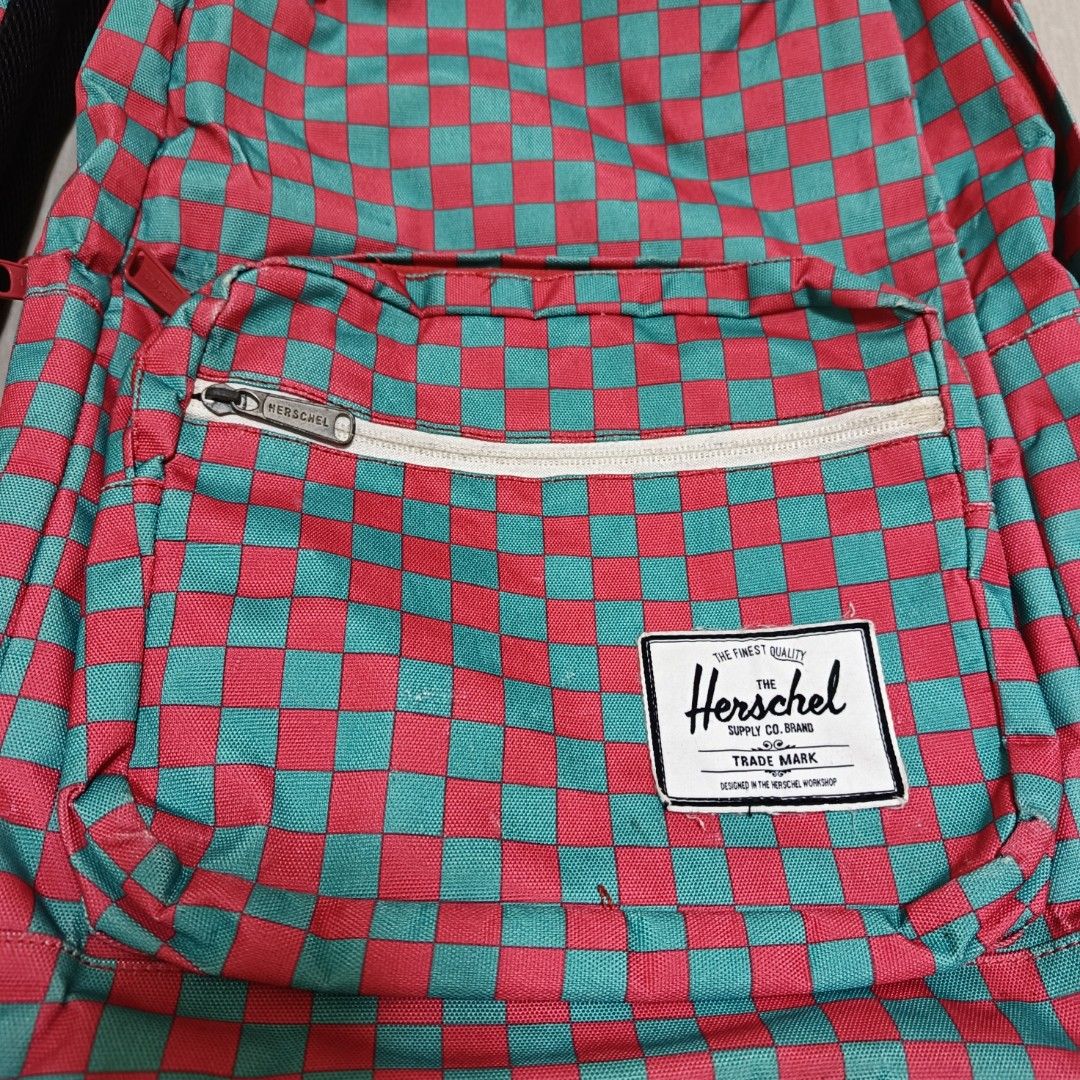 Herschel Supply Co. Checkered Pink and Turquoise Backpack (Category: Backpacks) located in Nasugbu. Submitted by staffpicks1515 (Listing ID 1470093393, Image 3). Description: - Brand: Herschel - Design: Bright pink and turquoise checkered pattern - Storage: Main compartment with laptop sleeve and front zip pocket - Details: Classic woven patch label, white zipper tape, and adjustable straps with black hardware - Interior: Signature striped fabric