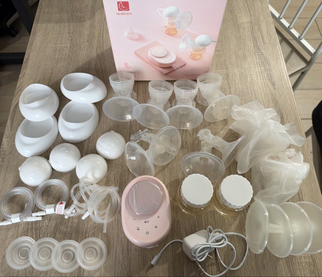 Horigen Double Electric Breast Pump Set with Box (Category: Breastfeeding & Bottle Feeding) located in Pasay City. Submitted by calmcloud.5b2569 (Listing ID 1469955910, Image 1). Description: - Horigen Double Electric Breast Pump in a cute pastel pink color - Comes complete with main digital display unit, power adapter, multiple tubing sets, bottles with caps, shields, valves, and spare parts - Screen still has the original protective plastic fil