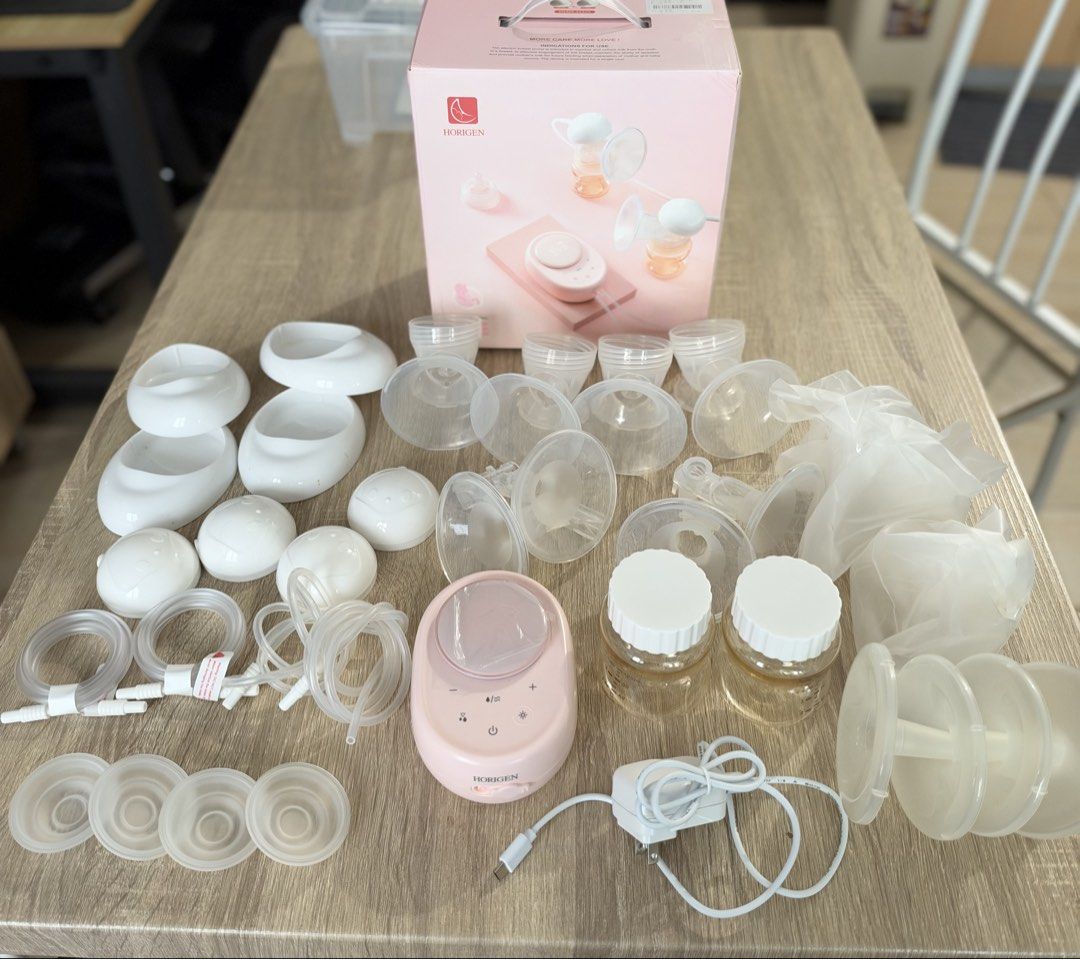 Horigen Double Electric Breast Pump Set with Box (Category: Breastfeeding & Bottle Feeding) located in Pasay City. Submitted by calmcloud.5b2569 (Listing ID 1469955910, Image 2). Description: - Horigen Double Electric Breast Pump in a cute pastel pink color - Comes complete with main digital display unit, power adapter, multiple tubing sets, bottles with caps, shields, valves, and spare parts - Screen still has the original protective plastic fil
