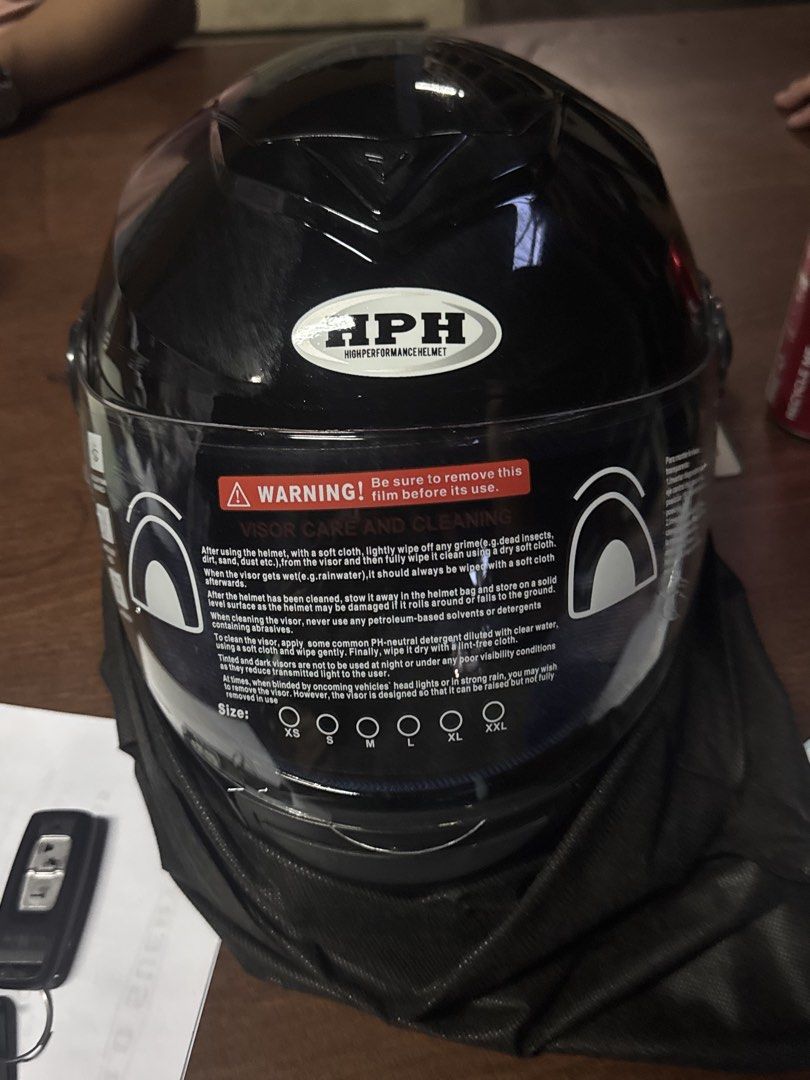 HPH High Performance Helmet Black Full Face (Category: Caps & Hats) located in Manila. Submitted by sheinevida (Listing ID 1470082763, Image 1). Description: - Brand: HPH High Performance Helmet - Type: Full face motorcycle helmet - Finish: Smooth glossy black with center front vent - Visor: Crystal clear, zero scratches, includes original warning sticker with size markings (L to XL) - Inclusion: Comes with a black fabric storage bag.