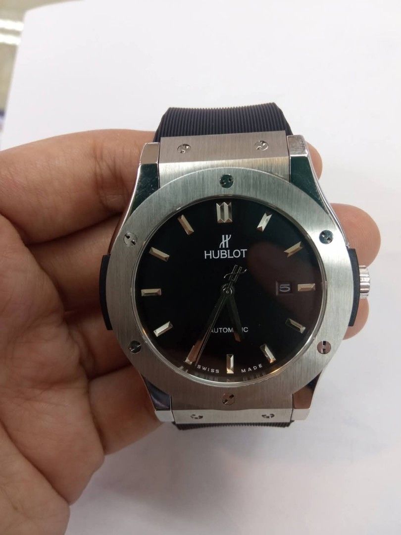 Hublot Geneve Chronograph Watch Rubber Strap (Category: Luxury Watches) located in Las Pinas. Submitted by teampeewee888 (Listing ID 1470023426, Image 3). Description: - Brand: Hublot Geneve - Type: Chronograph wristwatch - Dial: Black carbon-style with contrasting Arabic numerals and 3 sub-dials - Date Display: Positioned between 4 and 5 o'clock - Strap: Textured black rubber strap with deployment clasp - Bezel: Round black bezel with signature 