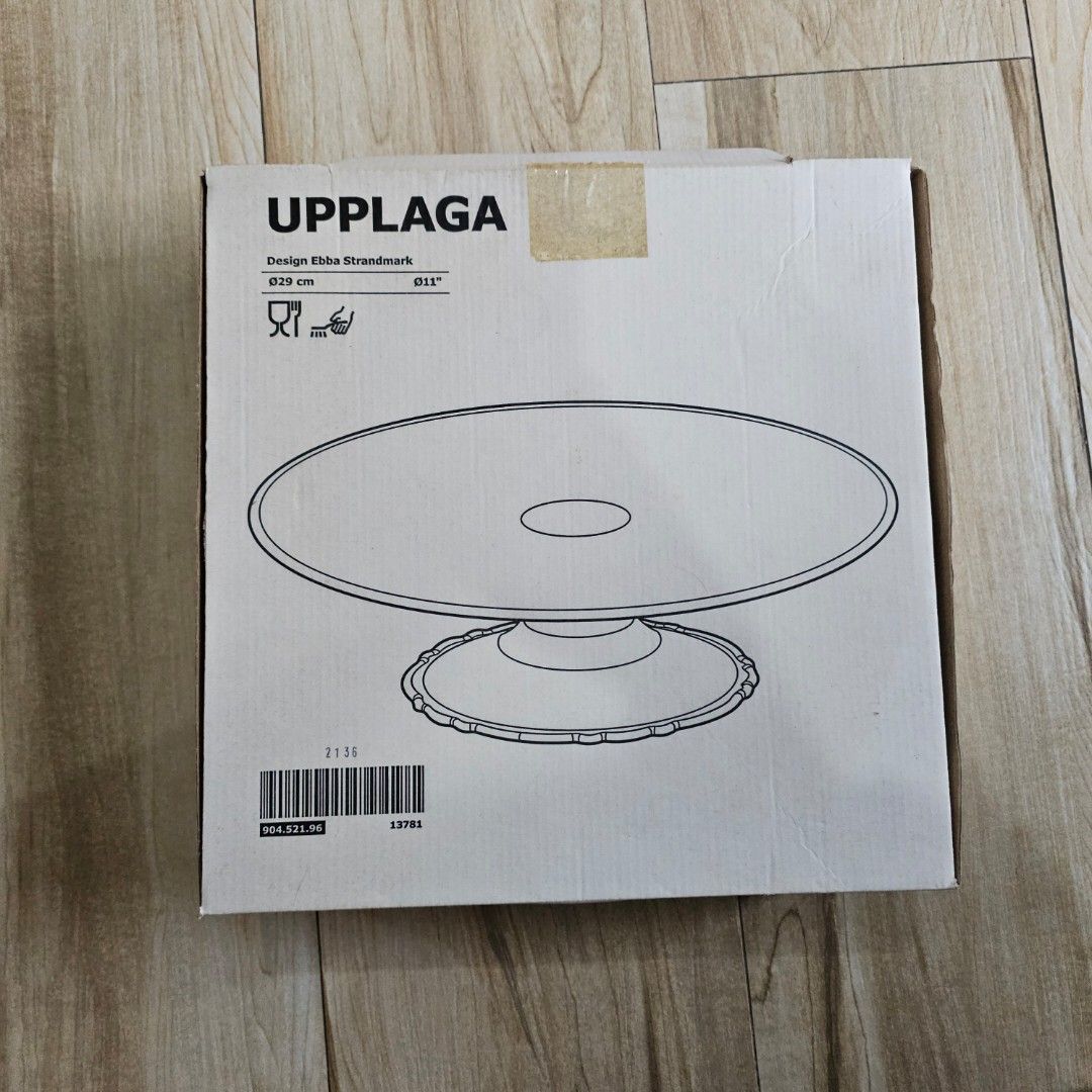 IKEA UPPLAGA Cake Stand with Base 29 cm (Category: Bakeware) located in Makati City. Submitted by goldenbird.001 (Listing ID 1470022313, Image 1). Description: - Authentic IKEA UPPLAGA cake stand - Diameter: 29 cm - Material: Premium white ceramic with a lovely scalloped edge base - Designer: Ebba Strandmark - Condition: Brand new in original packaging/box with barcode - Perfect for displaying cakes, pastries, and desserts for any occasion.