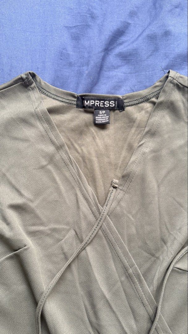 IMPRESS! Sage Green Wrap Dress Size S (Category: Dresses) located in Manila. Submitted by livebear-e9f3 (Listing ID 1469966393, Image 3). Description: - Brand: IMPRESS! - Style: Short-sleeve wrap dress with V-neckline and tie waist - Color: Sage green - Size: Small - Condition: Brand new with tags (BNWT), never worn - Material/Origin: Made in Bangladesh - Price tag: $49.99 (Compare at $85.00) - Price is negotiable.