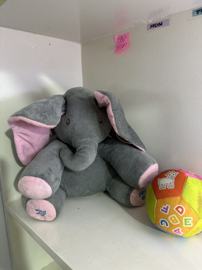 Interactive Elephant Plush Toy with Sound (Category: Plushies & Soft Toys) located in Quezon City. Submitted by swift.thriftz (Listing ID 1470118829, Image 1). Description: Interactive grey elephant plush toy with pink ears and feet. Features 'sing' and 'play' embroidery on the feet. Soft fabric, perfect for toddlers. Requires 3 AA batteries with an on/off switch. No battery cover.