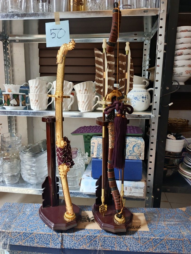 Japanese Samurai Sword and Bow Decorative Set with Stands (Category: Vintage Collectibles) located in Quezon City. Submitted by valerieluarez (Listing ID 1470132360, Image 2). Description: - Japanese ornamental decor set (Golden katana replica + mini bow & arrow) - Detailed dragon handle and ornate gold scabbard with purple/white wrapping - Includes feathered arrows - Comes with dark wood display stands for both items - Great statement pieces for