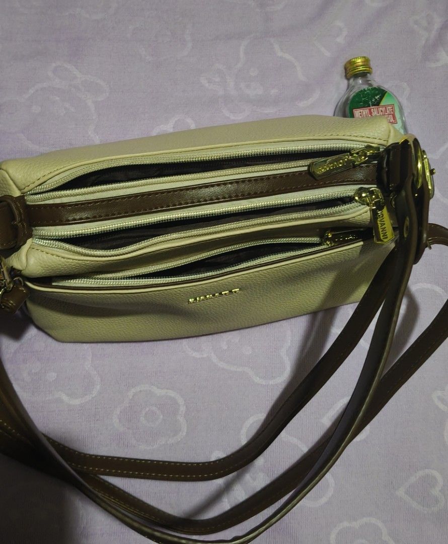 Jovanni Multi-compartment Shoulder Bag (Category: Shoulder Bags) located in Villasis. Submitted by bunnybabe08 (Listing ID 1470132871, Image 3). Description: • Brand: Jovanni • Material: Textured Faux Leather / Synthetic Leather • Color / Hardware: Beige (Tan / Cream) with Brown Trim | Gold-toned zippers and hardware plate • Condition: Like new, used only twice. Flawless exterior, clean interior, and all gold zippers work smoothly. • Inclusions: 