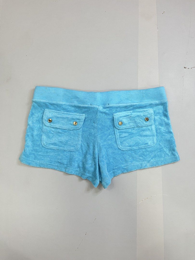 Juicy Couture Blue Terrycloth Logo Shorts (Category: Shorts) located in Mabalacat. Submitted by aas_thriftfings (Listing ID 1470102986, Image 2). Description: - Brand: Juicy Couture - Color: Bright blue - Material: Soft and comfortable terrycloth - Waistband: Drawstring with gold-tone hardware - Pockets: Back flap pockets with gold snap buttons - Details: Floral rhinestone J logo embroidered on the front leg - Style: Casual loungewear - Mode of P