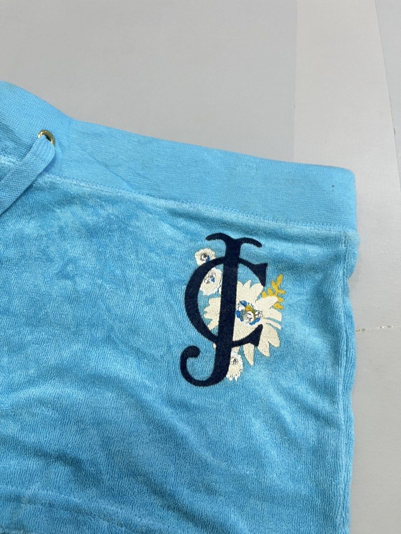 Juicy Couture Blue Terrycloth Logo Shorts (Category: Shorts) located in Mabalacat. Submitted by aas_thriftfings (Listing ID 1470102986, Image 3). Description: - Brand: Juicy Couture - Color: Bright blue - Material: Soft and comfortable terrycloth - Waistband: Drawstring with gold-tone hardware - Pockets: Back flap pockets with gold snap buttons - Details: Floral rhinestone J logo embroidered on the front leg - Style: Casual loungewear - Mode of P