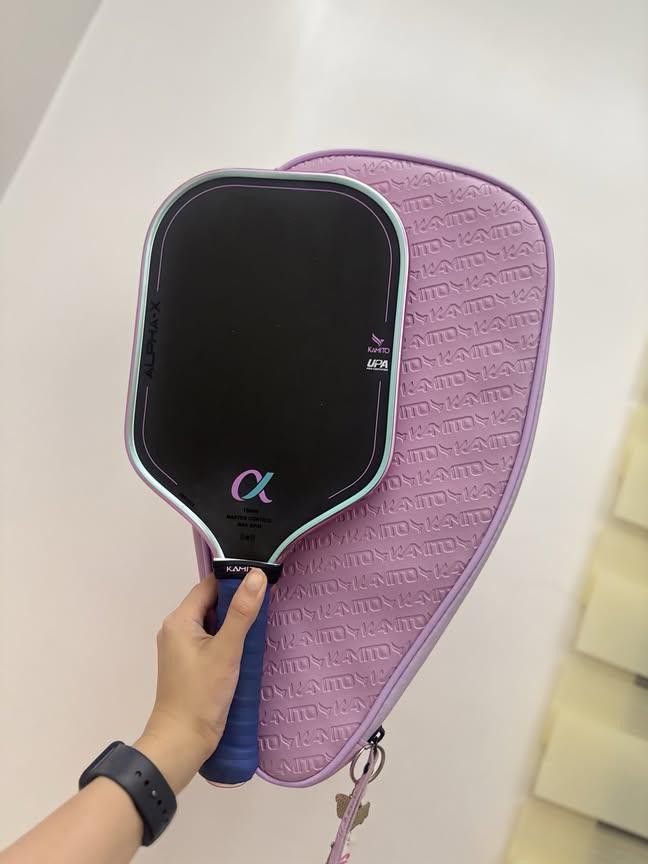 Kamito Alpha-X Pickleball Paddle with Cover (Category: Racket and Ball Sports) located in Manila. Submitted by k.apolinario (Listing ID 1469984550, Image 1). Description: - Brand/Model: Kamito Alpha-X 16mm Pickleball Paddle - Design: Black surface with striking purple and blue accents, featuring the alpha symbol near the base - Handle: Comfortable wrapped blue handle - Inclusion: Matching purple Kamito zippered cover with all-over embossed logo -