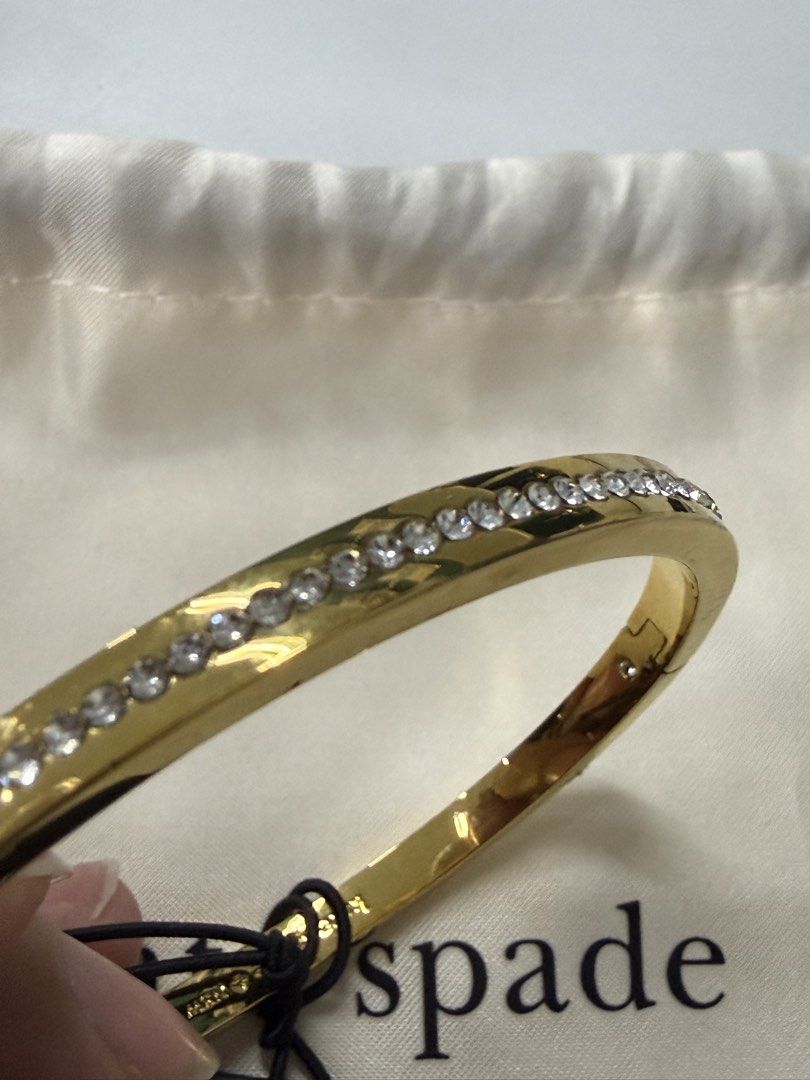 Kate Spade Ring It Up Pave Bangle Gold (Category: Bracelets) located in Quezon City. Submitted by bekyas_closet (Listing ID 1470089477, Image 2). Description: - Brand: Kate Spade - Condition: Brand new - Material/Design: Gold-tone metal with a row of sparkling clear stones on the outer edge - Closure: Hinged with a secure clasp - Model Number: O0RU2240 - Colorway: Clear / Gold - Inclusion: Comes with a white dust pouch.