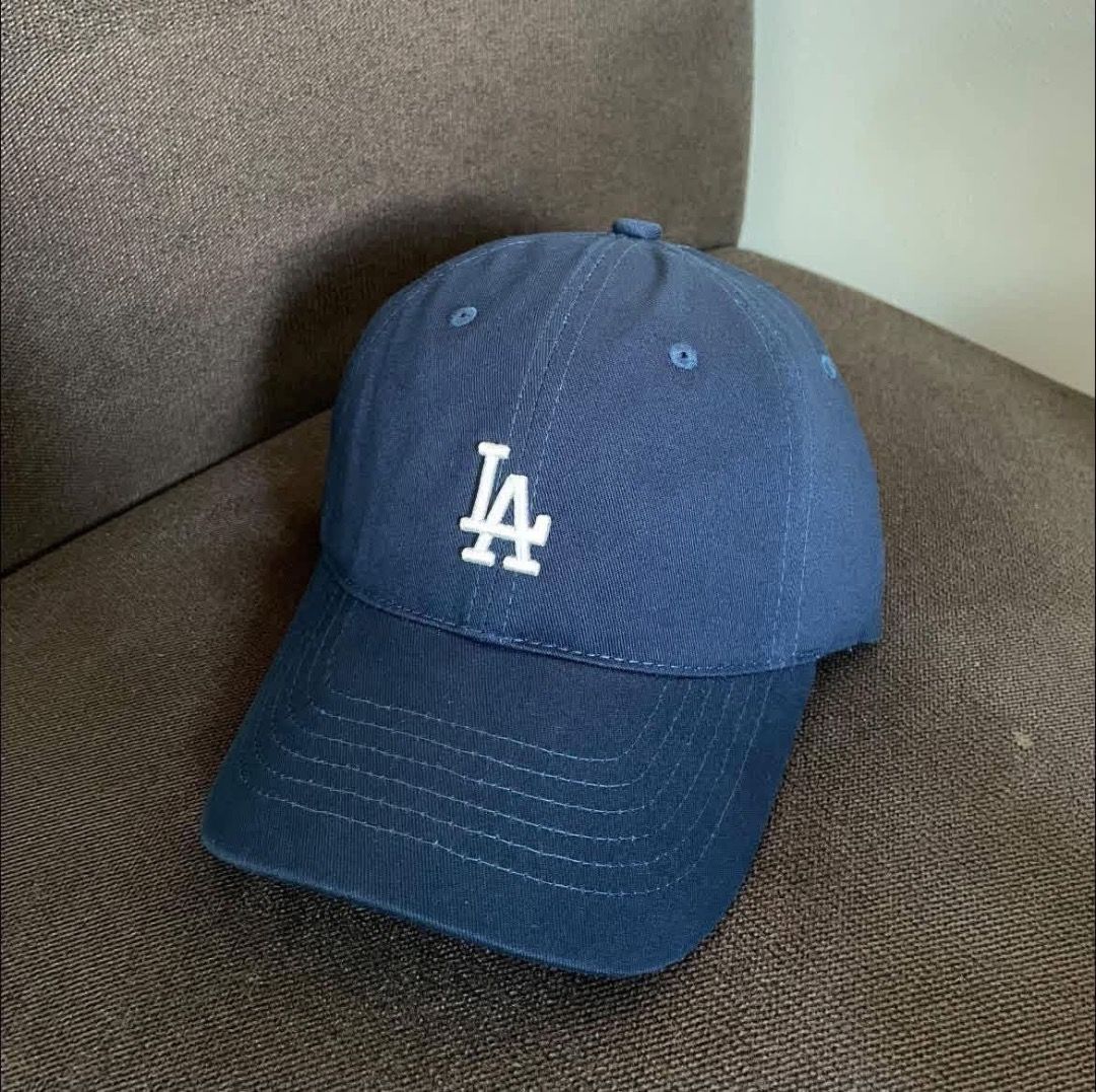 LA Dodgers Navy Blue Baseball Cap (Category: Caps & Hats) located in Paranaque City. Submitted by yanie.ae (Listing ID 1469995904, Image 1). Description: - Color: Navy blue with white embroidered LA logo - Style: Classic six-panel construction with curved brim - Fit: Adjustable back strap for a custom fit - Condition: Clean fabric with a well-structured crown that holds its shape - Ideal for: Everyday casual outfits and sun protection.