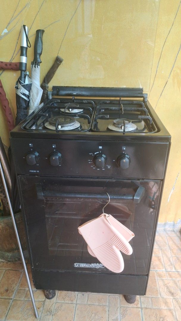 La Germania FS530 10 Gas Range and Oven (Category: Cookers) located in Manila. Submitted by noobsaibot84901 (Listing ID 1469957921, Image 1). Description: - Brand/Model: La Germania FS530 10 - Color: Black - Cooktop: 4 gas burners - Oven: Integrated oven with glass window and handle - Controls: Rotary knobs located on the left side - Inclusion: Free pink silicone oven mitt - Condition: Pre-loved with normal signs of use and some grease marks arou