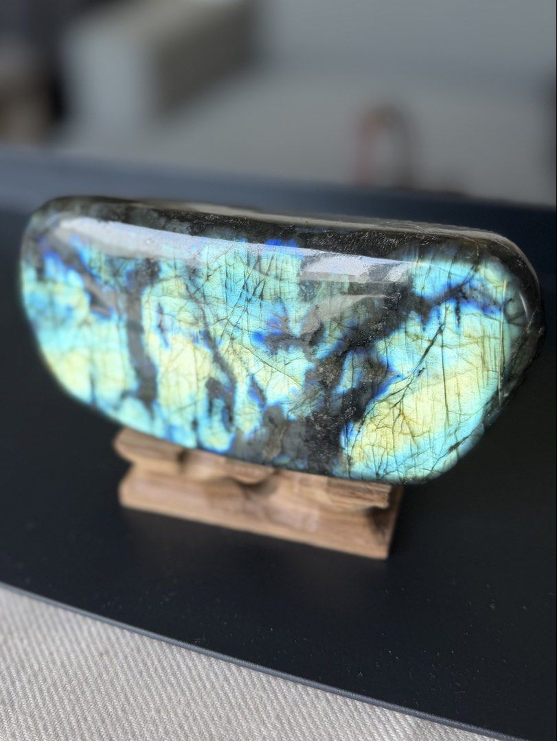 High flash Labradorite Stone with Wooden Stand (Category: Other Home Decor) located in Paranaque City. Submitted by heyandeey (Listing ID 1469952904, Image 1). Description: - High-quality labradorite stone with striking electric blue and yellow flash - Wonderfully smooth, polished surface - ideal for meditation, display, or crystal collections - Flawless condition with no chips or scratches - Includes a custom-carved wooden display stand Approx s