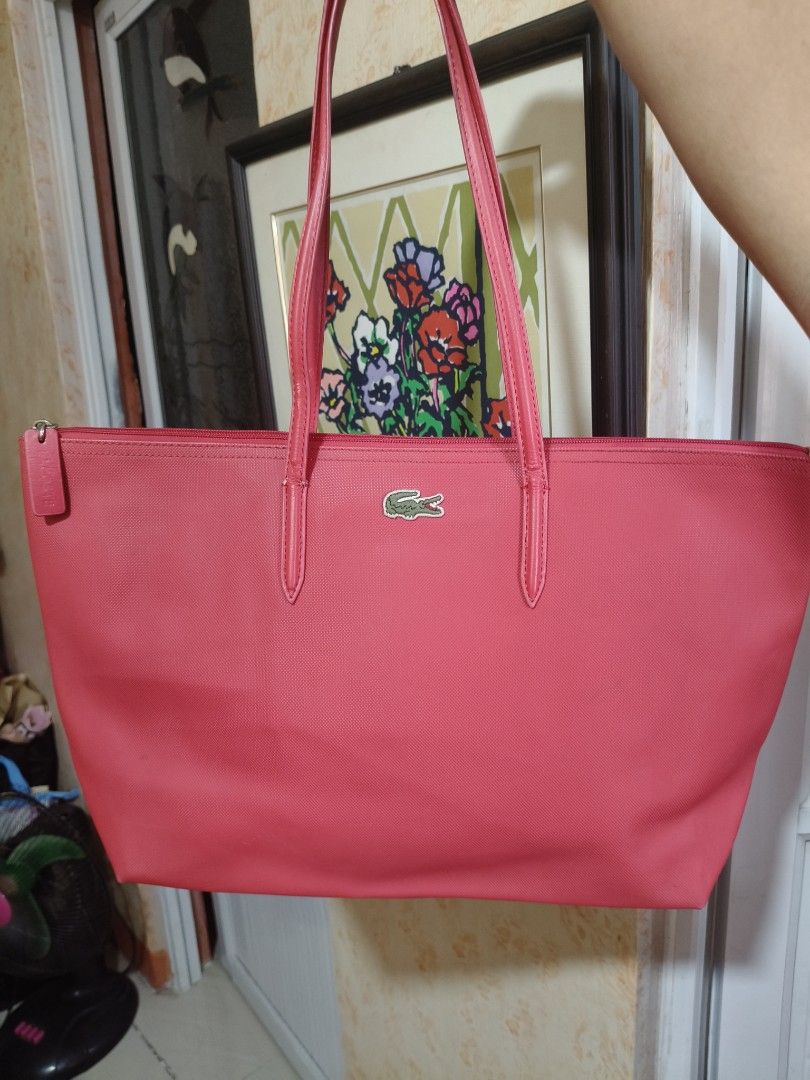 Lacoste Red Tote Bag (Category: Tote Bags) located in Bulacan. Submitted by pesa_39 (Listing ID 1469979506, Image 1). Description: - Brand: Lacoste - Color: Red - Material: Durable textured nylon - Closure: Secure zip top - Design: Dual shoulder straps with iconic embroidered green crocodile logo - Interior: Spacious everyday tote bag - Condition: Minor wear near strap base stitches -Maganda, authentic Lacoste tote bag.