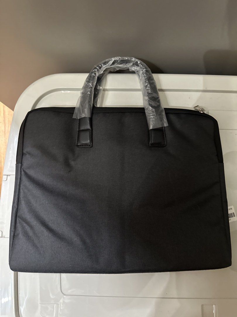 Laptop Briefcase Bag (Category: Briefcases) located in Quezon City. Submitted by bqchane (Listing ID 1470055720, Image 1). Description: - Brand new black business briefcase for laptops and documents - Dual carrying handles still wrapped in original protective plastic with QC tag attached - Clean fabric exterior with a secure zippered main compartment - Structured, simple, and professional design - Ideal for daily office work, business trips, or s