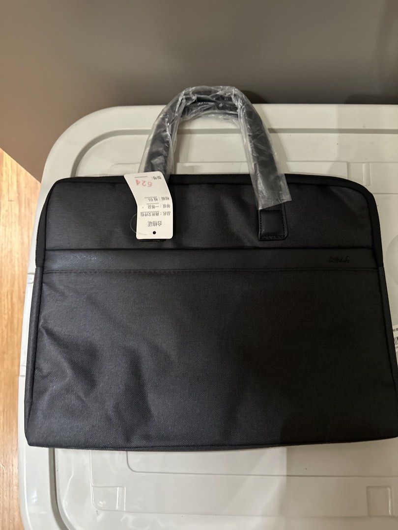 Laptop Briefcase Bag (Category: Briefcases) located in Quezon City. Submitted by bqchane (Listing ID 1470055720, Image 2). Description: - Brand new black business briefcase for laptops and documents - Dual carrying handles still wrapped in original protective plastic with QC tag attached - Clean fabric exterior with a secure zippered main compartment - Structured, simple, and professional design - Ideal for daily office work, business trips, or s