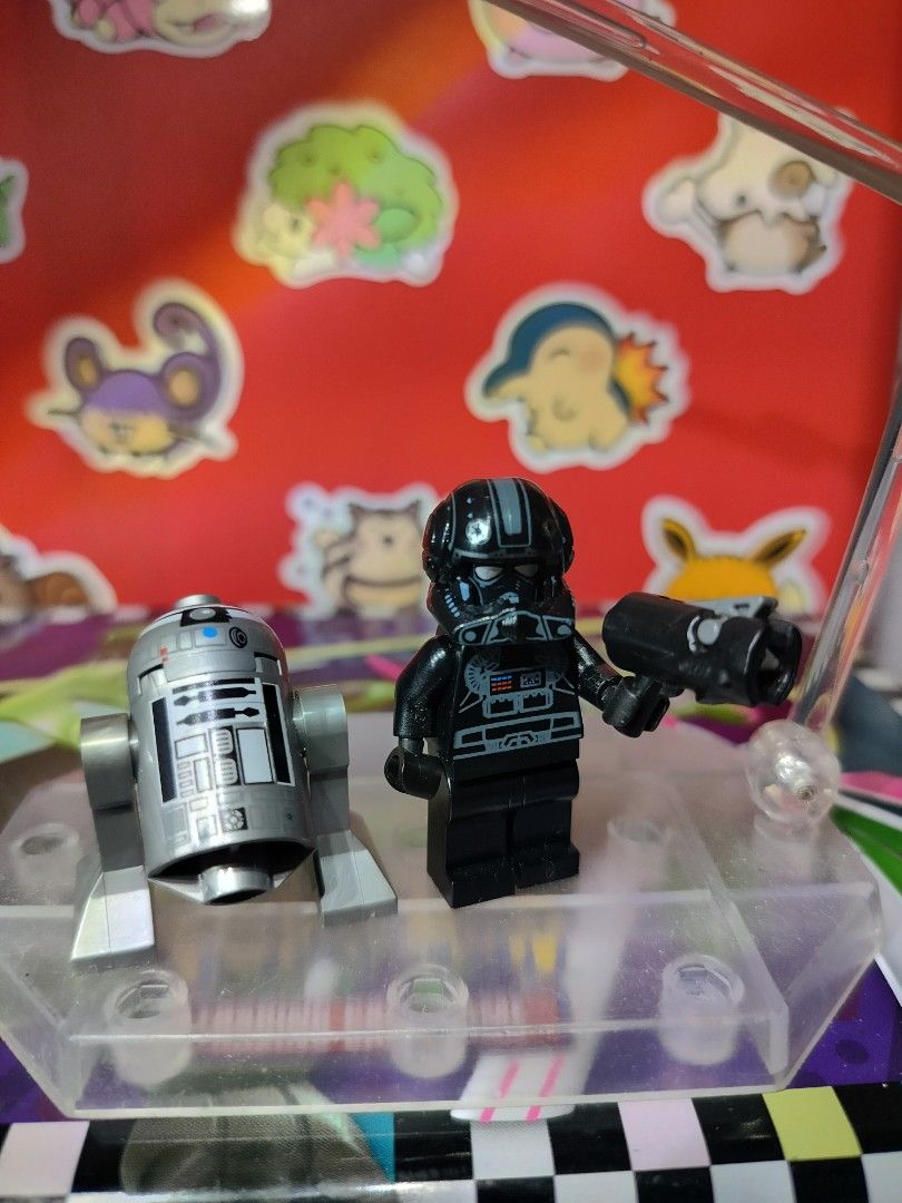 LEGO Star Wars Imperial V-Wing Pilot & R2-Q2 Droid Bundle (Category: Lego & Building Sets) located in San Antonio. Submitted by lansbitshop (Listing ID 1470092812, Image 2). Description: Minifigure: Genuine LEGO Imperial V-wing Pilot (ID: sw0304). Features a detailed black flight suit torso print with control panels, grey utility stripes, and a specialized Imperial pilot helmet insignia. Droid: Includes the authentic matching silver and dark char