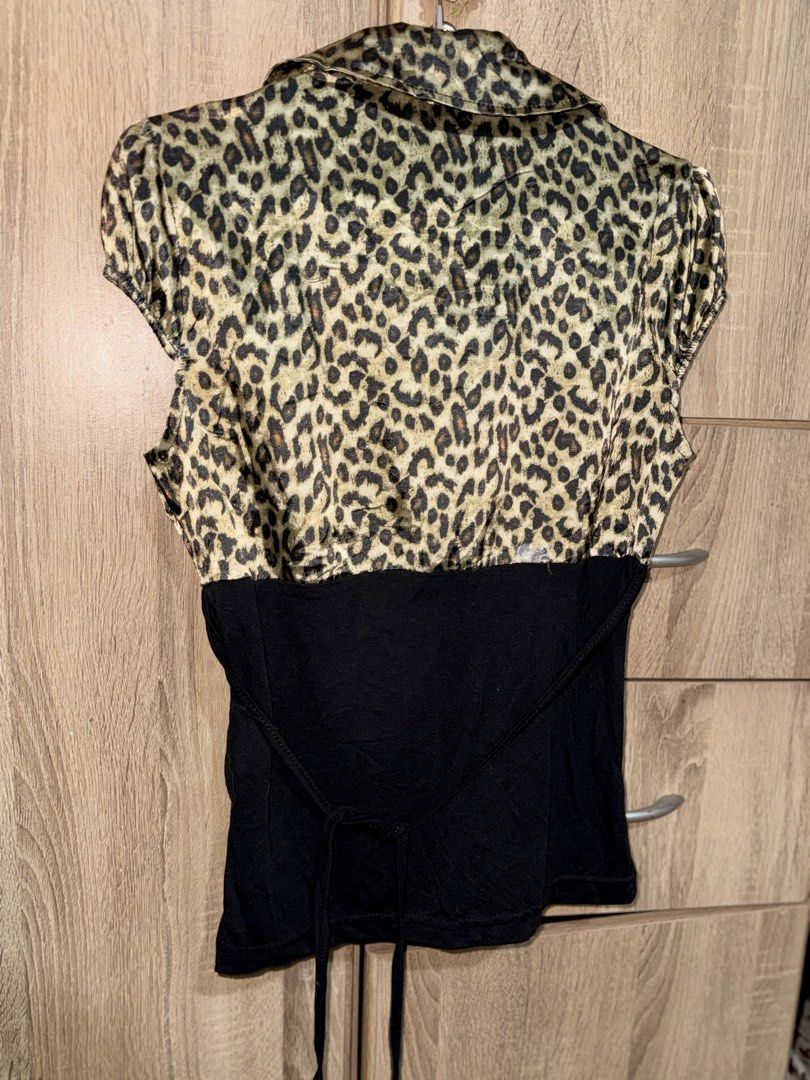 Leopard Print Ruffle Collar Corset Top (Category: Blouses) located in Manila. Submitted by tenshiii185 (Listing ID 1470058205, Image 2). Description: - Style: Y2K vintage vibe - Design: Leopard print top with collared v-neck and ruffled trim - Details: Solid black fitted lower half with front buttons and adjustable back tie strings - Sleeves: Short cap sleeves - Styling: Easy to pair with denim or skirts.