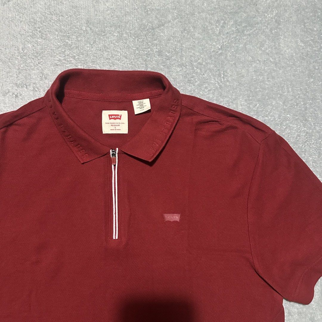 Levi's Red Half-Zip Polo Shirt Size L (Category: Tshirts & Polo Shirts ) located in Villaverde. Submitted by bakatzy_secondhand_garments (Listing ID 1470093651, Image 3). Description: - Brand: Levi's - Color: Dark Red - Size: L (Regular Fit) - Material: Textured pique cotton - Details: Half-zip neck with white contrast piping, embossed collar lettering, and red logo tabs - Origin: Made in India - Condition: Clean inside and out, all labels intact