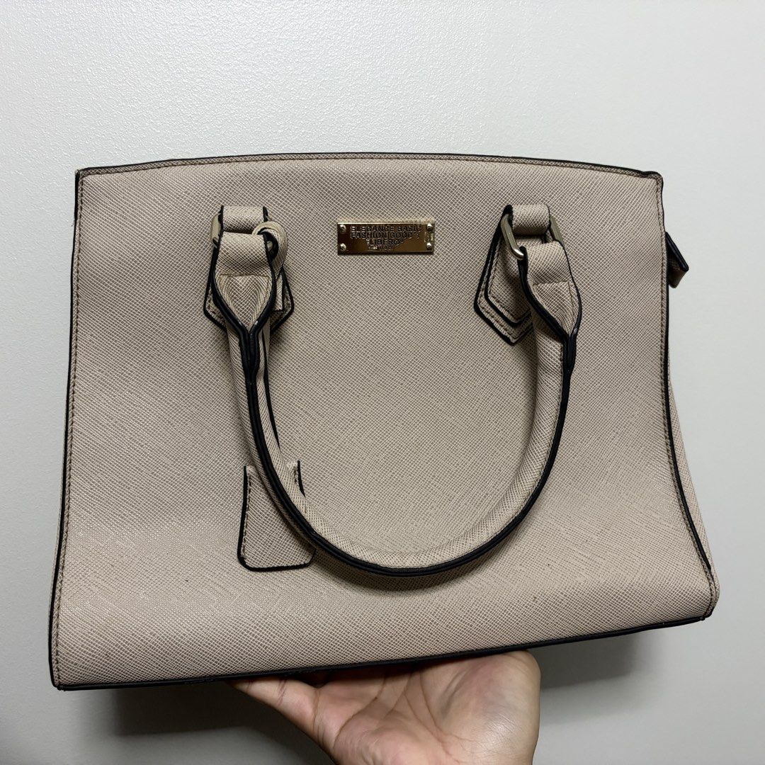 Libero Elegance Basic Fashion Goods Handbag (Category: Luxury Bags & Wallets) located in Tanza. Submitted by iamdhana (Listing ID 1469988390, Image 1). Description: - You can search the brand. Issue: Lightly used but the gold hardware ay mejo tarnished na and the long strap is mejo maluwag na yung clasp :) Brand: Libero - Color: Elegant beige with contrasting black edge detailing on handles - Material: Durable Saffiano texture faux leather - Hard