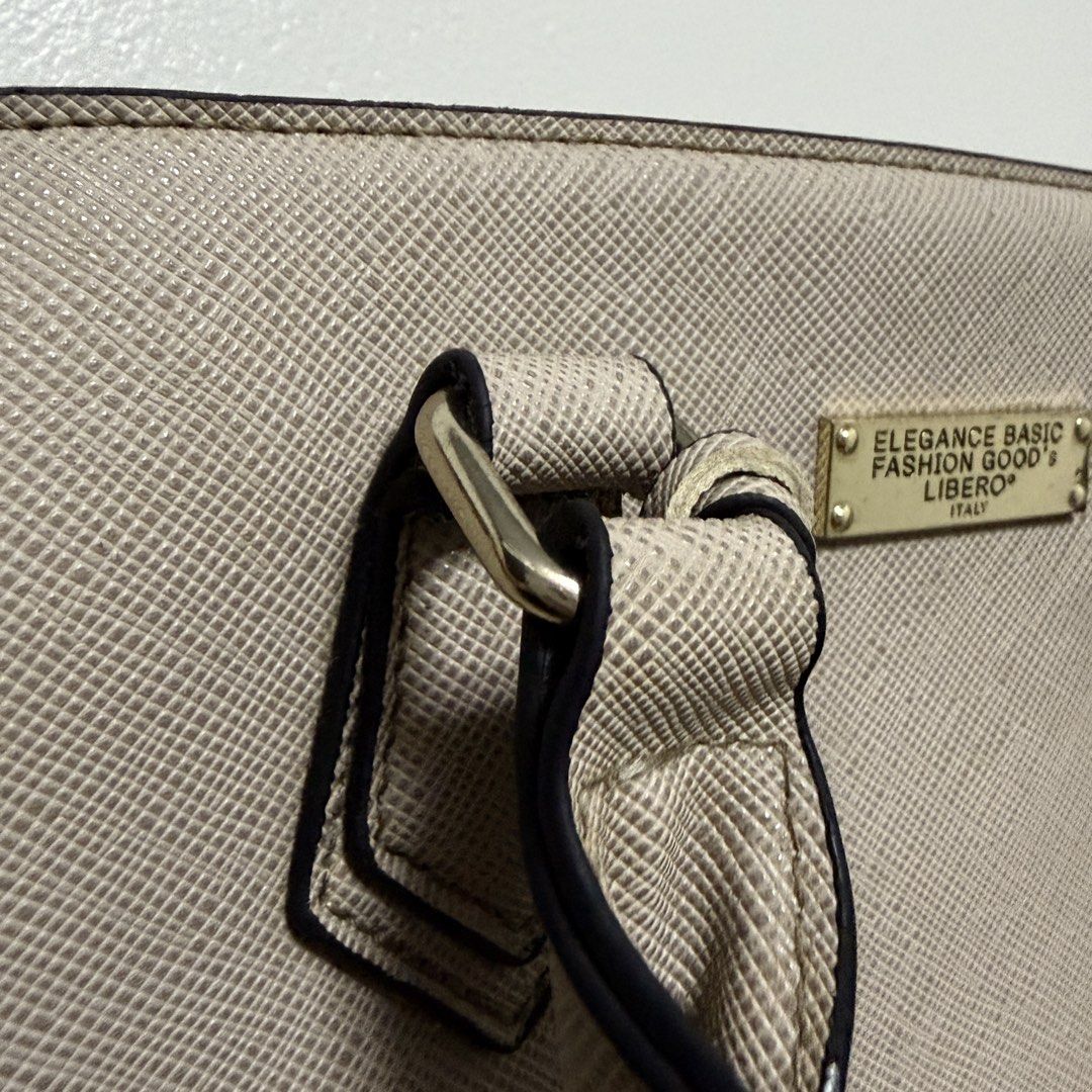 Libero Elegance Basic Fashion Goods Handbag (Category: Luxury Bags & Wallets) located in Tanza. Submitted by iamdhana (Listing ID 1469988390, Image 3). Description: - You can search the brand. Issue: Lightly used but the gold hardware ay mejo tarnished na and the long strap is mejo maluwag na yung clasp :) Brand: Libero - Color: Elegant beige with contrasting black edge detailing on handles - Material: Durable Saffiano texture faux leather - Hard