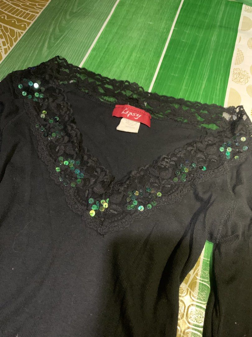 Lipsy Black Long Sleeve Top with Sequins (Category: Longsleeves) located in Cebu City. Submitted by selamethrift (Listing ID 1470062625, Image 2). Description: - Brand: Lipsy - Color: Classic black - Style: Long-sleeve, fitted silhouette with standard length - Neckline: V-neck featuring black lace trim - Details: Stitched with shiny green and blue sequins for a subtle sparkle - Fabric: Comfortable ribbed texture with great stretch - Occasion: Per