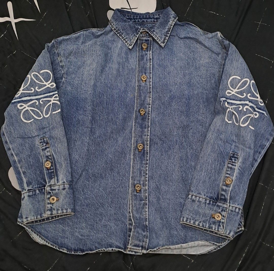 Loewe Anagram Overshirt Denim Shirt Jacket (Category: Luxury Apparel) located in Puerto Princesa. Submitted by jercksthriftph (Listing ID 1469957131, Image 2). Description: - Brand: Loewe - Size: 36 oversized fits large to XL - Style: Oversized denim shirt jacket / overshirt - Color: Classic blue mid-wash - Details: White Anagram embroidery, distressed spliced arm details, branded metal buttons, pointed collar, and buttoned cuffs - Fit: Oversized