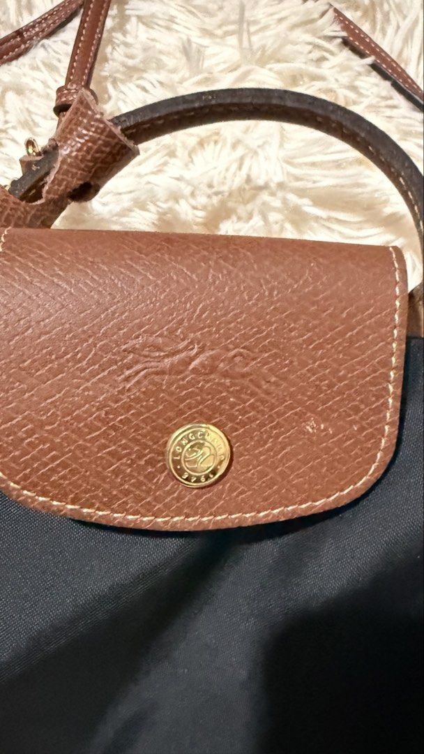 Longchamp Le Pliage Original Pouch (Category: Luxury Bags & Wallets) located in Pasay City. Submitted by erinsclosetph (Listing ID 1470022929, Image 3). Description: Preloved and in excellent overall condition. Features the iconic lightweight nylon body with leather flap and comes with shoulder straps for versatile styling. Condition: Rank A–AB Flaws: Minor scratch on the leather flap and signs of wear underneath. Nylon is in excellent condition,