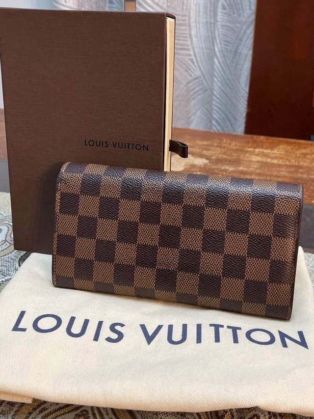 Louis Vuitton Damier Sarah Wallet (Category: Luxury Bags & Wallets) located in Pasay City. Submitted by watch.authentic_ph (Listing ID 1470007643, Image 2). Description: - Brand: Louis Vuitton - Pattern: Classic Damier Ebene canvas (Brown check) - Closure: Front flap with snap button - Interior: Multiple compartments for cards and cash - Condition: Well-maintained shape with clean edges - Inclusions: Original dust bag and branded box included.