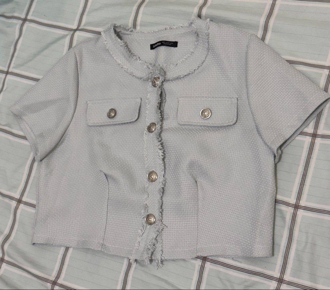 Lovito Light Blue Tweed Short Sleeve Jacket (Category: Coats, Jackets and Outerwear) located in Manila. Submitted by misskendrapreloved (Listing ID 1470099825, Image 1). Description: - Brand: Lovito - Color: Light blue - Style: Short sleeve cropped tweed jacket - Neckline: Round neck with frayed trim edges - Closure: Front button closure with silver ornate buttons - Pockets: Two chest pockets with button flaps - Fabric: Textured tweed throughout 
