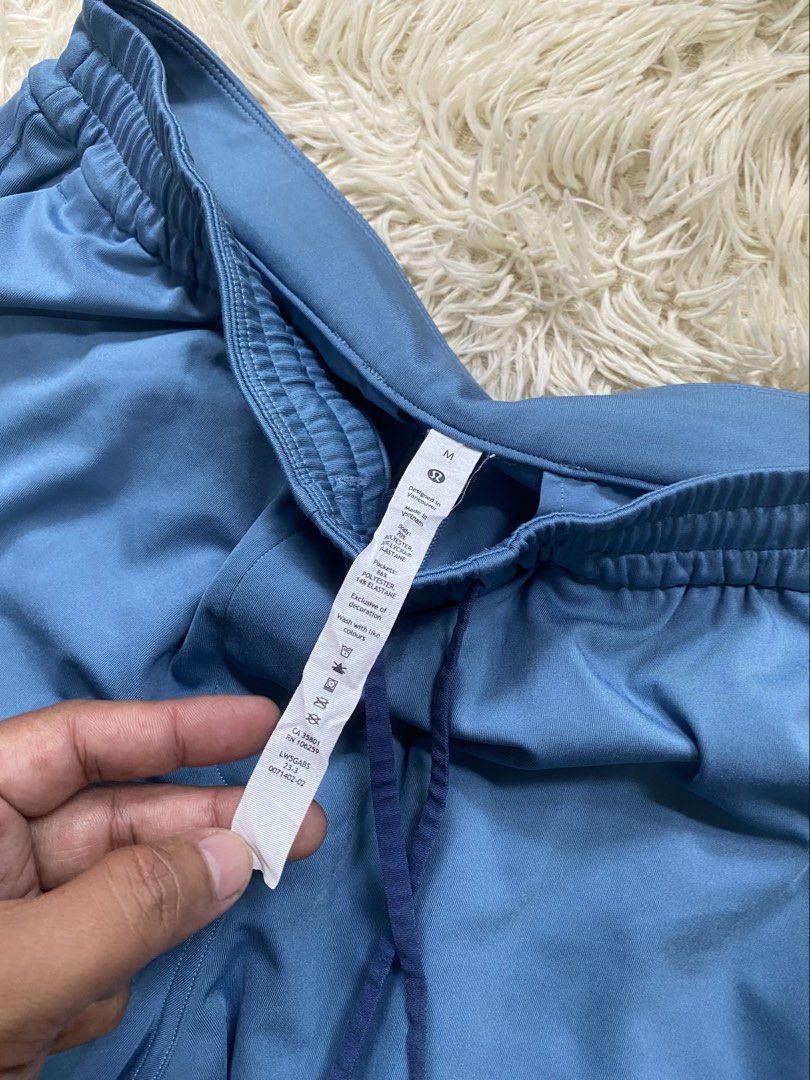 Lululemon Blue Pants Size M (Category: Activewear) located in Manila. Submitted by switchcity (Listing ID 1470075618, Image 3). Description: - Brand: Lululemon - Color: Blue - Size: Medium fits 30-34 - Fit: Relaxed straight leg - Waistband: Elastic with matching drawstring and logo-detail ends - Pockets: Two back welt pockets with signature embroidered logo - Material: Comfortable synthetic blend - Condition: Great, clean, and well-kept.