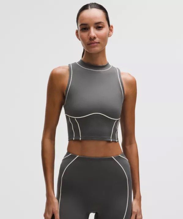 Lululemon Crop Tank (Category: Sleeveless) located in Quezon City. Submitted by lovedbysia (Listing ID 1469977348, Image 1). Description: - Brand: Lululemon - Color: Dark grey with light contrast piping and panel lines - Style: High neckline, racerback, contour seaming - Fabric: Super soft athletic material - Size: 10 - Condition: Brand new with original store tags attached, never worn.
