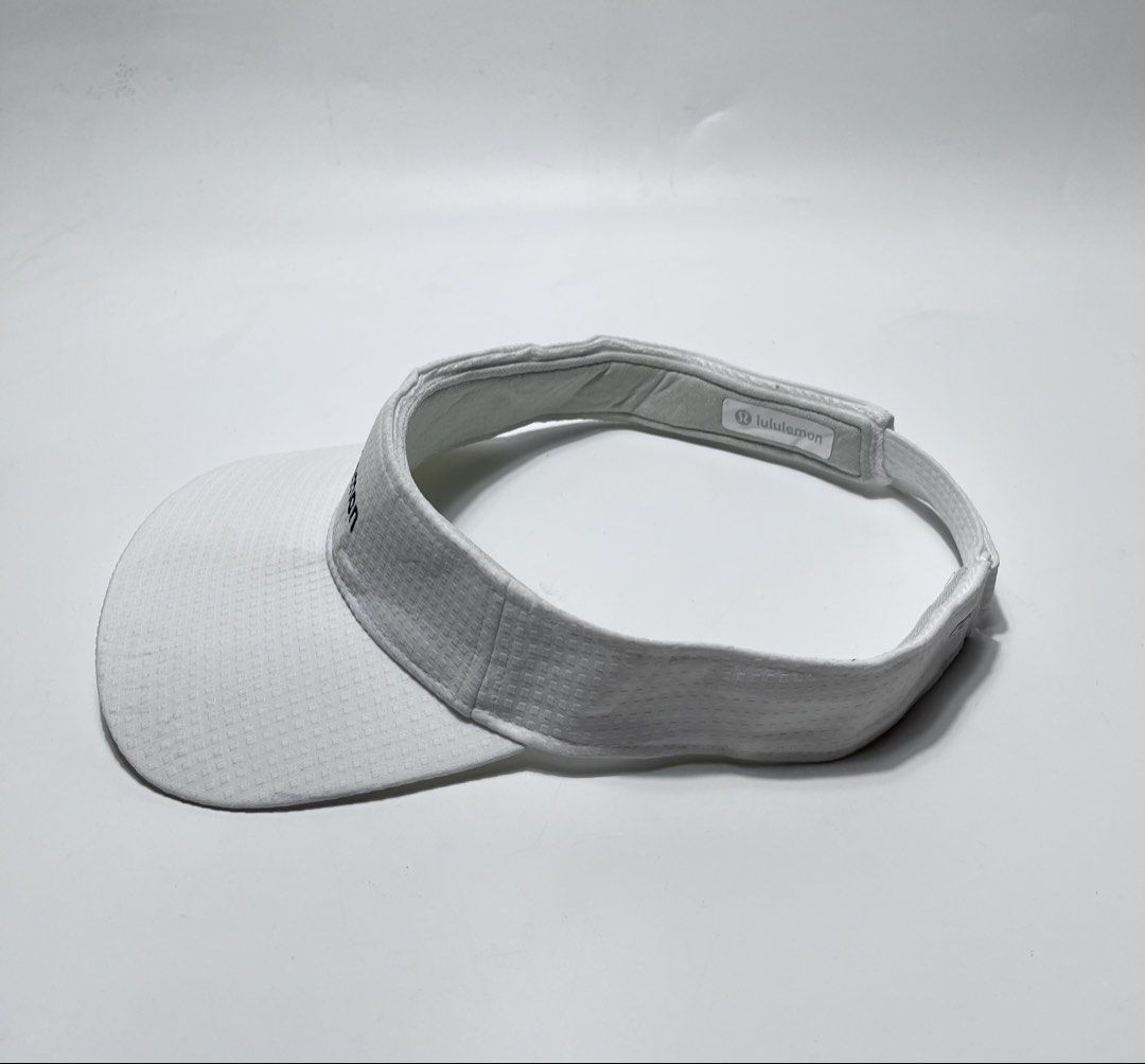 Lululemon White Athletic Visor (Category: Hats & Beanies) located in Iloilo. Submitted by fromthebins.ilo2 (Listing ID 1470106065, Image 2). Description: - Brand: Lululemon - Color: White with subtle textured pattern - Logo: Embroidered on the front panel and interior sweatband tag - Fit: Adjustable back strap with buckle and lululemon wordmark - Material: Lightweight and breathable athletic fabric - Ideal for: Running, tennis, golf, and outdoor 