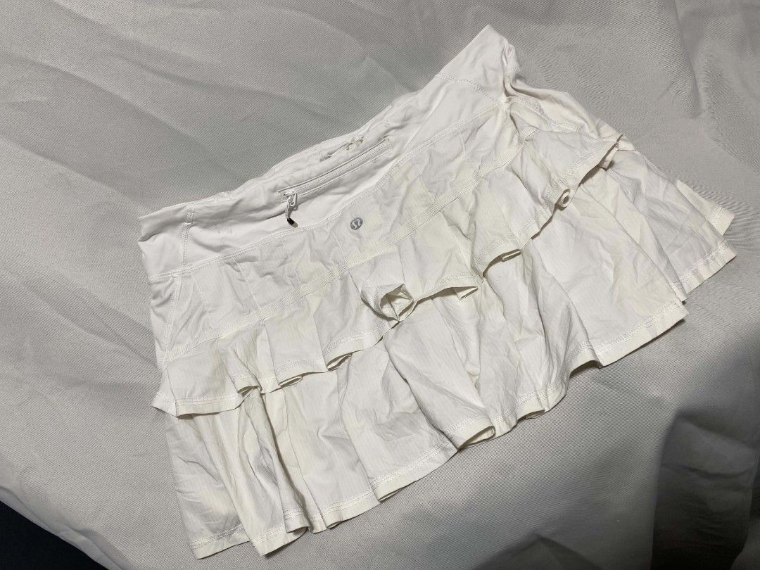 Lululemon White Ruffle Pleated Athletic Skort (Category: Skirts) located in Pasacao. Submitted by kishhuschka (Listing ID 1470079756, Image 1). Description: - Authentic white Lululemon athletic skirt - Built-in shorts for coverage and comfort - Trendy tiered ruffles on the front - Back zippered pocket and interior mesh pocket for essentials - Iconic Lululemon logo on the front and clear interior brand tag - Perfect for tennis, golf, or casual act