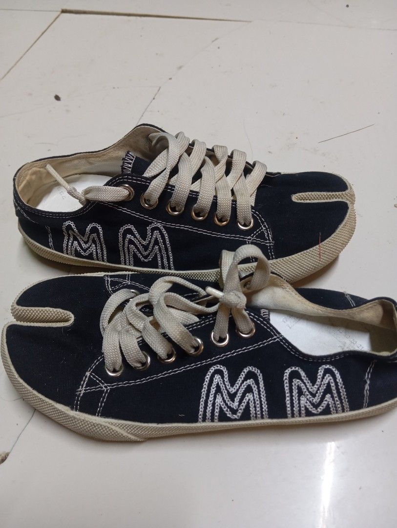 Maison Margiela Tabi Canvas Sneakers Black Size (Category: Sneakers) located in Calabanga. Submitted by younghustler. (Listing ID 1470104616, Image 3). Description: Maison Margiela Tabi canvas sneakers in black. Split-toe design with iconic white stitch detail on the heel. Thick cream laces and distinctive embroidered 'MM' logo branding on the side. Brown rubber chevron outsole. Made in Italy. Removable insoles included..