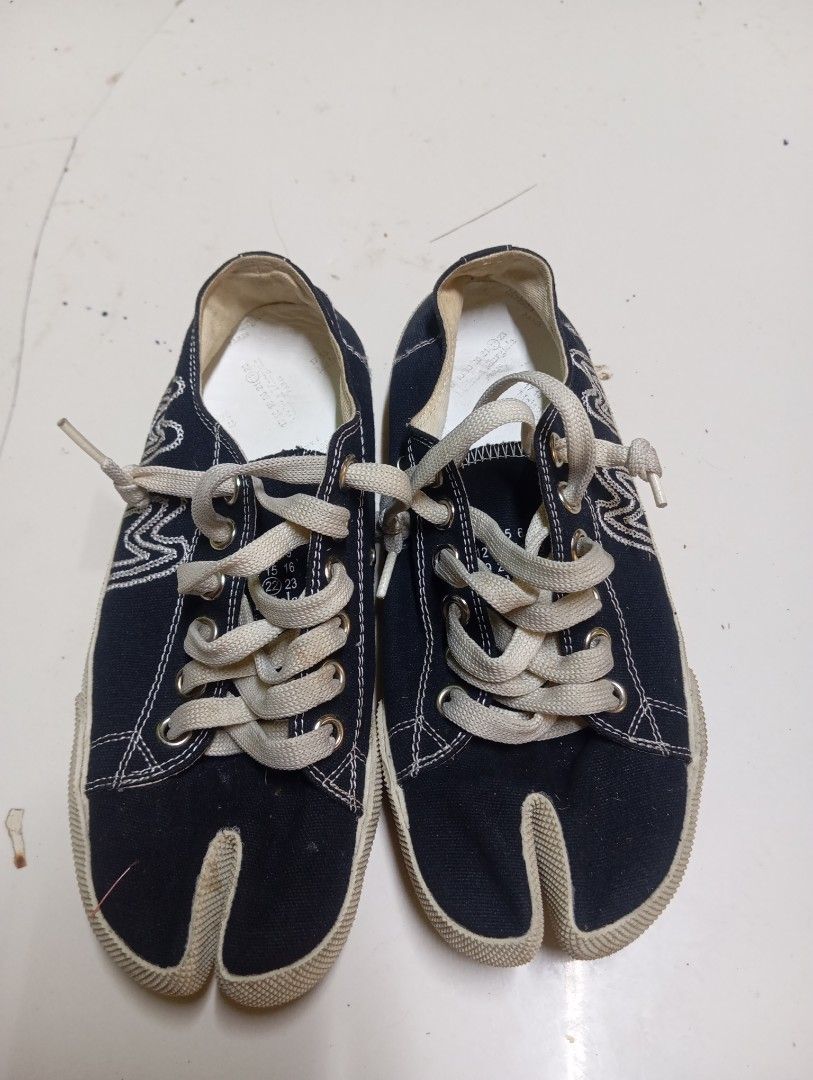 Maison Margiela Tabi Canvas Sneakers Black Size (Category: Sneakers) located in Calabanga. Submitted by younghustler. (Listing ID 1470104616, Image 1). Description: Maison Margiela Tabi canvas sneakers in black. Split-toe design with iconic white stitch detail on the heel. Thick cream laces and distinctive embroidered 'MM' logo branding on the side. Brown rubber chevron outsole. Made in Italy. Removable insoles included..