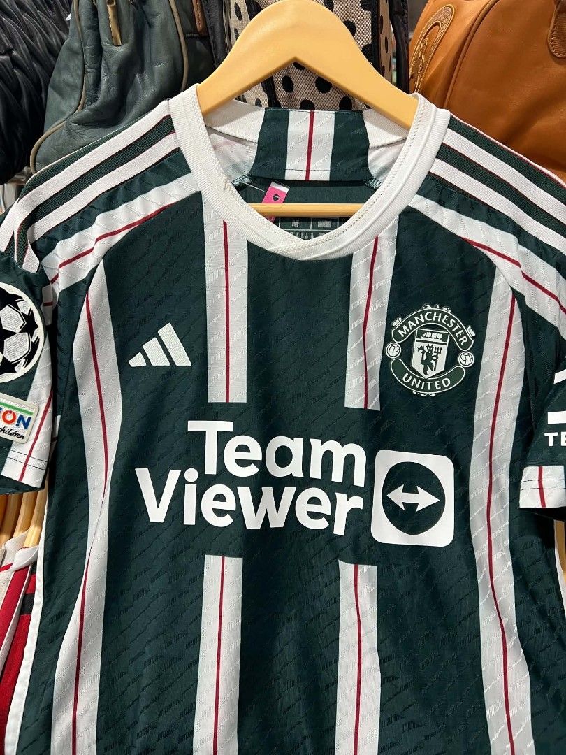 Manchester United Mount 7 Away Jersey (Category: Activewear) located in Urdaneta. Submitted by jayceegarage (Listing ID 1470095770, Image 3). Description: - Authentic Manchester United Away Jersey - Player: Mason Mount (#7) - Features TeamViewer sponsor, Adidas logo, and embroidered club crest - Includes official UEFA Foundation badge on the sleeve - Eye-catching green, white, and red striped pattern - Made in Vietnam with inner wash tag intact -