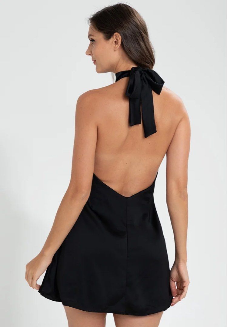MANGO Black satin halter neck mini dress with back bow (Category: Dresses) located in Taguig. Submitted by httpgrant (Listing ID 1469955439, Image 2). Description: - Color: Sleek Black - Fabric: Smooth satin finish - Design: High halter neckline with open back and ribbon bow tie at the neck - Fit: Fitted waist with short mini length - Closure: Easy zip closure at the lower back - Used once at a concert - Bought from MNG Glorietta srp 2995.