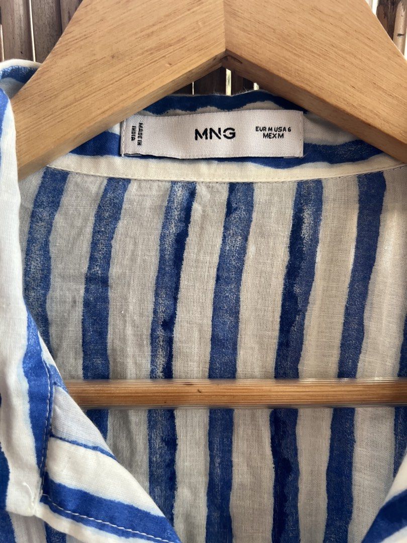 Mango Blue White Striped Button-Up Shirt Size M (Category: Blouses) located in Taguig. Submitted by bestthriftxx (Listing ID 1470012391, Image 3). Description: - Brand: Mango - Style: Blue and white striped button-up shirt - Size: EUR M / USA 6 / MEX M - Fit: Relaxed fit with long sleeves and button cuffs - Details: Classic collared neckline, front button closure, and one chest pocket - Material: Lightweight and comfortable for casual days or lay