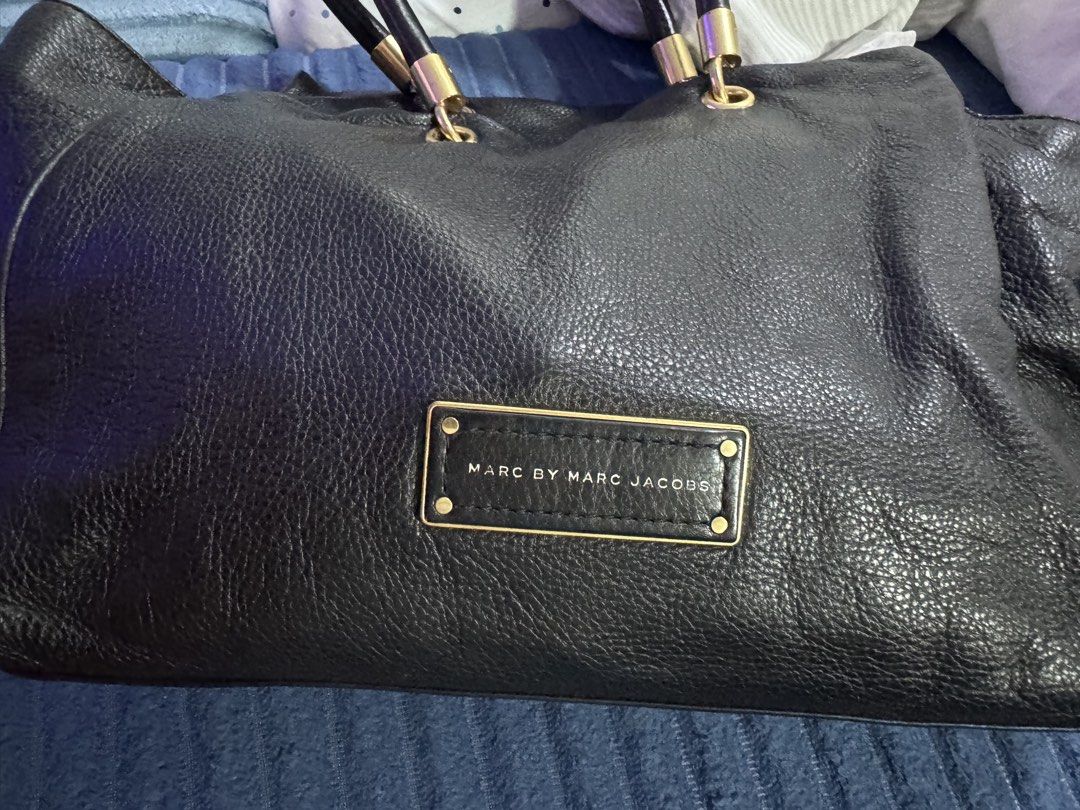 Marc by Marc Jacobs Classic Black Tote Bag (Category: Tote Bags) located in Paranaque City. Submitted by zen_80 (Listing ID 1469978411, Image 3). Description: - Brand: Marc by Marc Jacobs -- Authentic with original dustbag - Material: Premium black pebbled leather - Hardware: Gold-tone with engraved branding - Interior: Black fabric lining with zippered pocket and Made in Indonesia tag - Base: Structured with protective metal feet - Style: Classi
