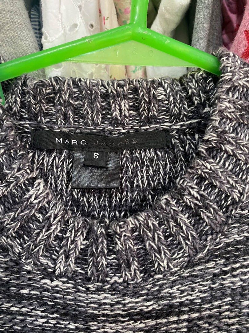 Marc Jacobs Black White Knit Sweater Size S (Category: Longsleeves) located in Tabuk. Submitted by collectors_thrift_shop (Listing ID 1470047491, Image 3). Description: - Brand: Marc Jacobs - Size: S (tag attached inside collar) - Color/Pattern: Black and white heathered yarn - Design: White embroidered lettering across the chest with decorative white stitching on the right shoulder seam - Details: Ribbed cuffs and hem - Care: Dry clean only - Co