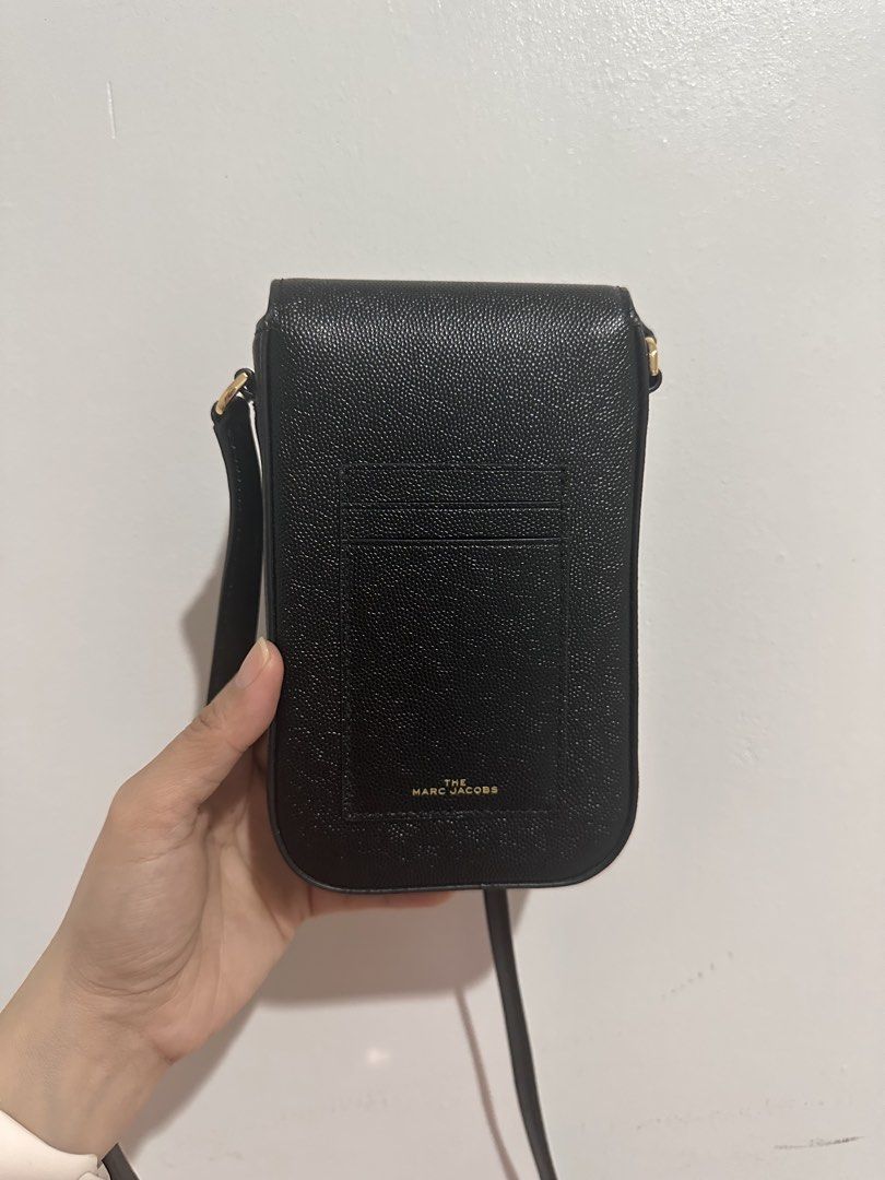 Marc Jacobs The J Link Phone Bag (Category: Luxury Bags & Wallets) located in Cainta. Submitted by xyzasisa (Listing ID 1469948537, Image 2). Description: - Brand: The Marc Jacobs - Material: Black textured leather - Hardware: Mixed gold and silver tone - Features: Front flap clasp, exterior card slots with gold foil branding, interior main compartment with extra card slots - Strap: Adjustable black leather strap with gold hardware - Condition: E