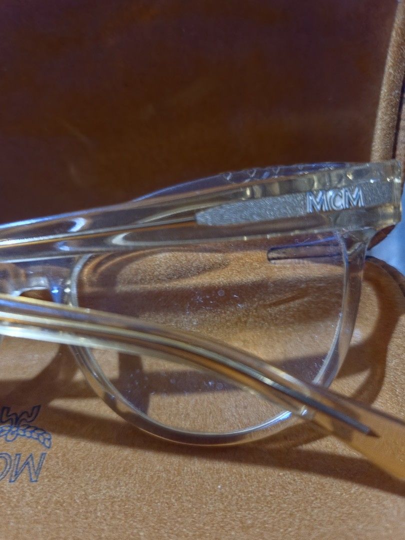 MCM Eyeglasses with Case (Category: Sunglasses & Eyewear) located in Las Pinas. Submitted by swiftdragon_0c099a (Listing ID 1470020646, Image 2). Description: - Authentic clear MCM frames with signature logo on arms - Stylish diamond-textured detailing near the temples - Sturdy construction with a classic, versatile shape - Includes matching signature cognac monogram hard case - Comes with brand new cleaning cloth still wrapped in plastic Swarovs