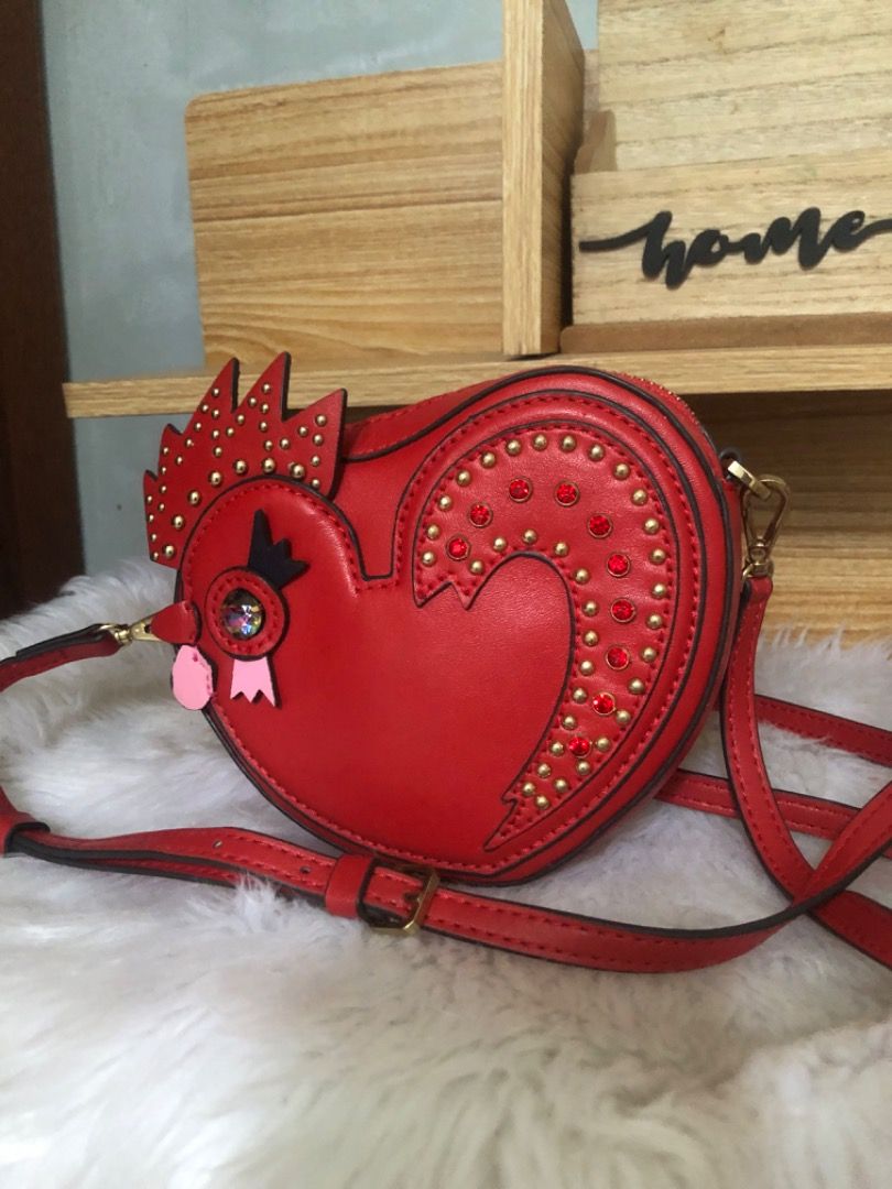 Mcm Limited edition Chicken Heart Shaped Small Bag (Category: Cross-body Bags) located in Lucena. Submitted by gracious_chin0436 (Listing ID 1469949351, Image 1). Description: - Fun red heart-shaped rooster/chicken novelty crossbody bag - Features sparkling red crystals and edgy gold-tone studs on the front - Secure gold zip-top closure and durable gold hardware - Practical back pocket complete with a gold metal brand plate - Long, adjustable mat