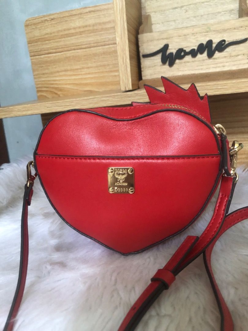 Mcm Limited edition Chicken Heart Shaped Small Bag (Category: Cross-body Bags) located in Lucena. Submitted by gracious_chin0436 (Listing ID 1469949351, Image 2). Description: - Fun red heart-shaped rooster/chicken novelty crossbody bag - Features sparkling red crystals and edgy gold-tone studs on the front - Secure gold zip-top closure and durable gold hardware - Practical back pocket complete with a gold metal brand plate - Long, adjustable mat