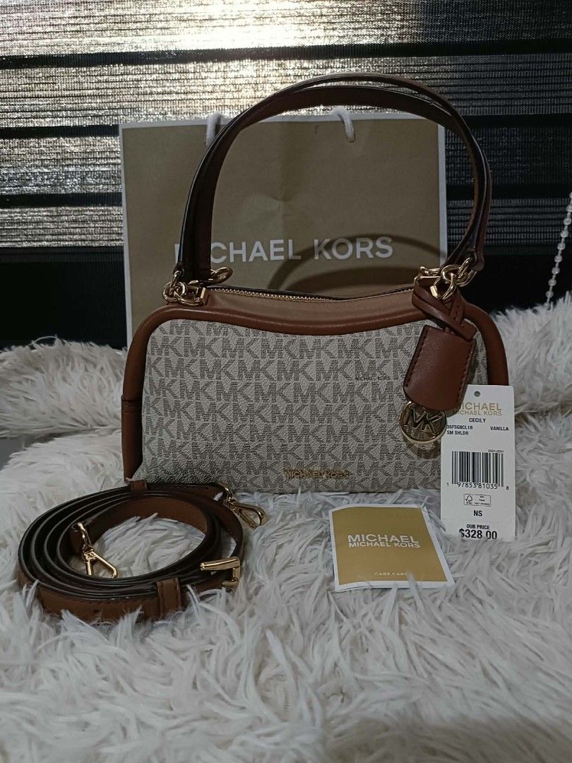 Michael Kors Cecily Monogram Shoulder Bag Vanilla (Category: Luxury Bags & Wallets) located in Iba. Submitted by royalgemini (Listing ID 1470037903, Image 2). Description: - 100% Authentic Michael Kors Cecily Small Shoulder Bag - Color: Vanilla monogram print with rich brown leather trim and gold-tone hardware - Signature hanging MK logo charm included - Versatile carry options: Dual top handles + detachable, adjustable strap - Brand new with pap